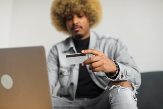 black man with afro looking at a credit card