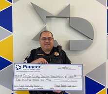 police officer holding a big check