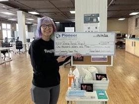woman with glasses holding check