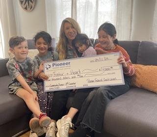 woman with children holding a large check