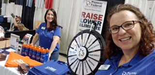 Pioneer employees running a booth with a roulette wheel