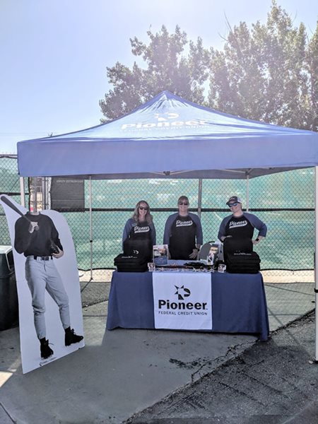 Team members working a booth at a Boise Hawks Game