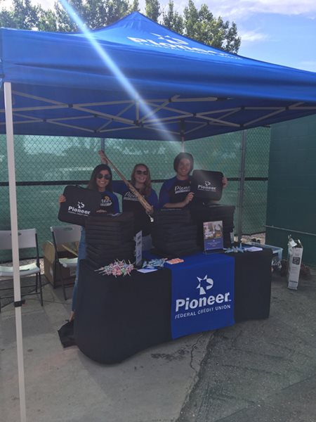 Pioneer team members working a booth at a Boise Hawks game