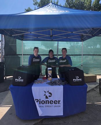 three employees running a booth at a Boise Hawks game