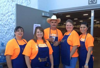 five pioneer volunteer in orange shirts and blue aprons