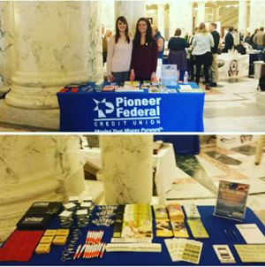 Two Pioneer employees with a booth full of branded swag and brochures