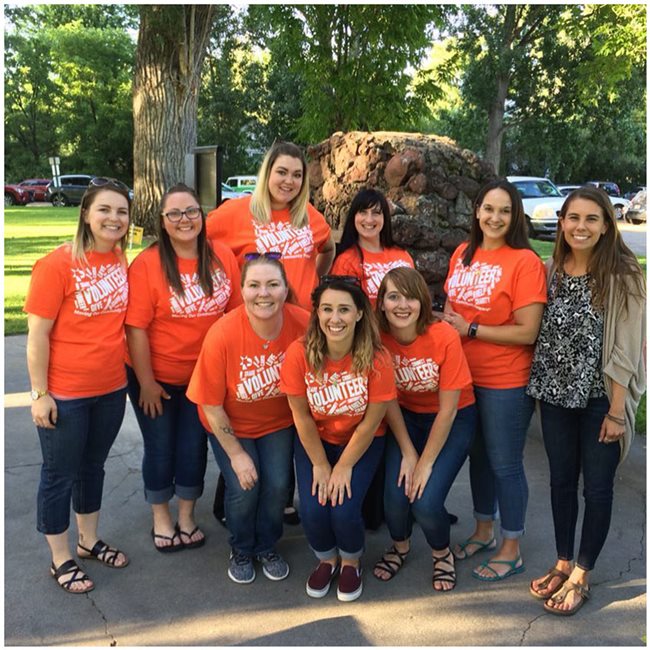 Pioneer volunteers in orange shirts out in a park