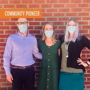 three people wearing masks