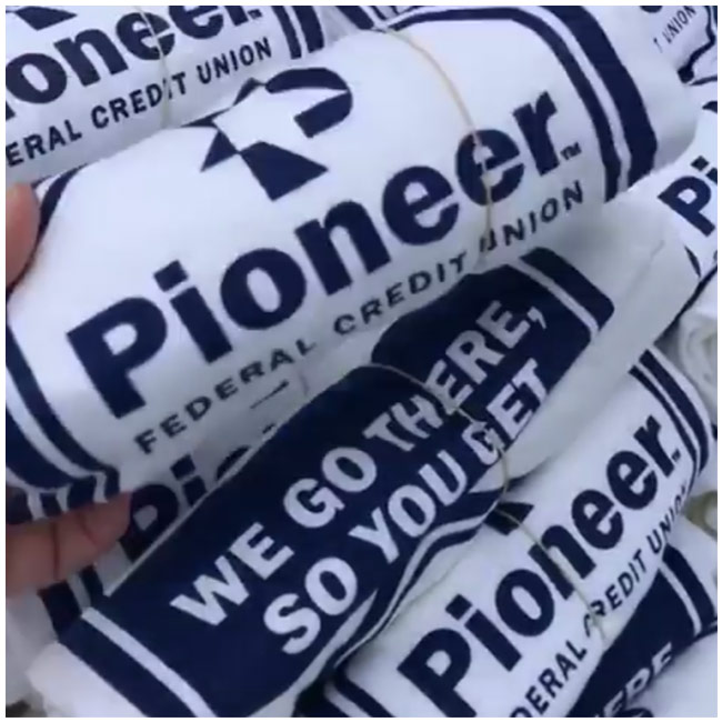 Several Pioneer T shirts rolled up and held together with a rubber band