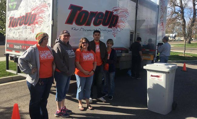 Five Pioneer volunteers standing next to a paper shredder truck