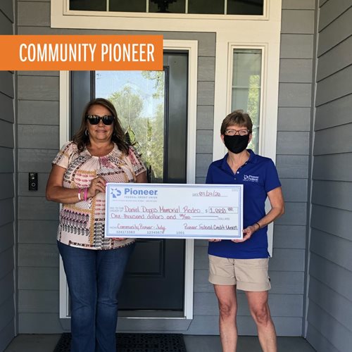 woman with Pioneer team member holding a large check