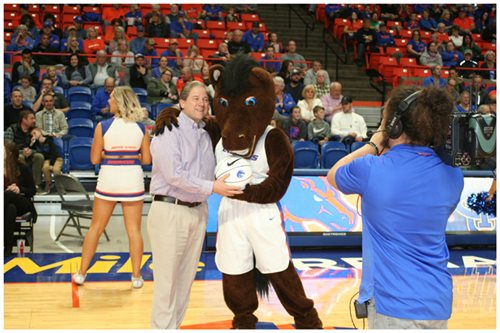 Curt Perry being handed a basketball by the BSU mascot