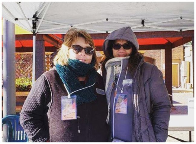 Two Pioneer employees wearing coats and managing a booth