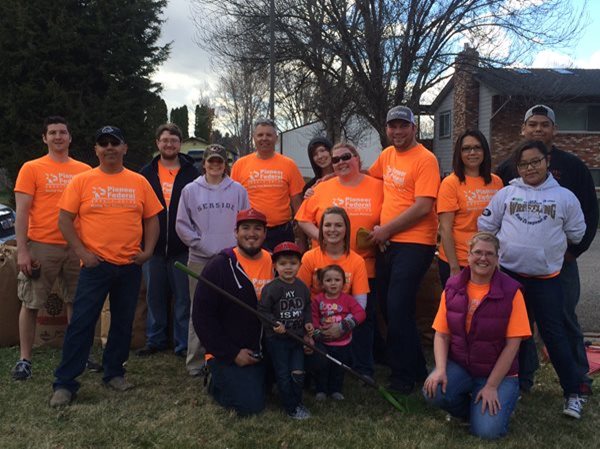 Pioneer volunteers in orange shirts after raking up leaves