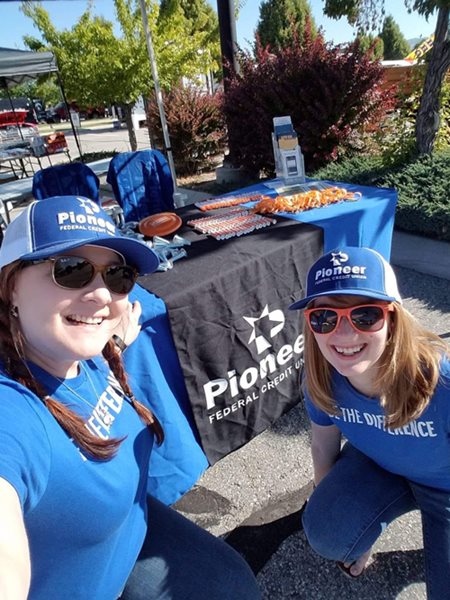 Two Pioneer team members working a booth for the chariots car show