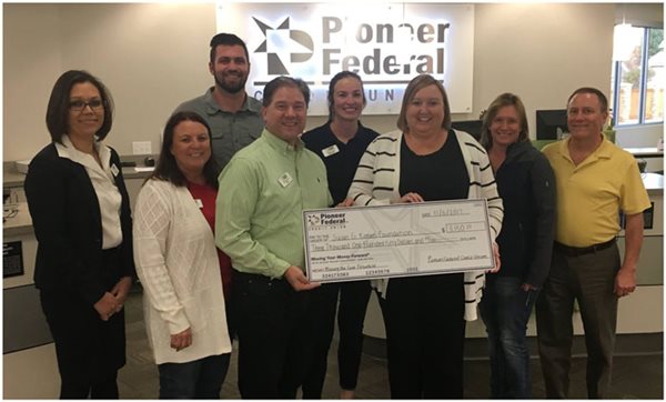 Pioneer employees presenting a large check to the Susan G Komen group
