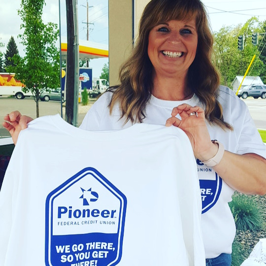 Woman holding a white Pioneer t-shirt