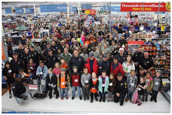 Large crowd at a Walmart filled with police officers, children, and other adults