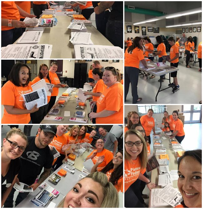 Pioneer volunteers in orange shirts putting packets together for attendees