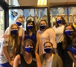 team members all wearing blue masks