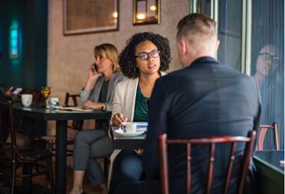 concerned woman talking to a man at a table