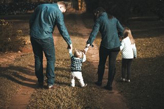 parents walking down a road with two kids