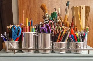 tons of art supplies stored in metal cups