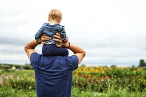 baby sitting on a man's shoulders