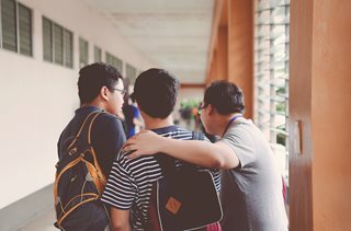 three young men walking down a hallway