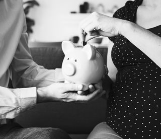 couple putting a coin in a piggy bank