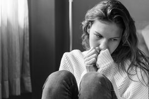 sad woman with hands over her mouth
