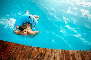boy in a pool with a float ring