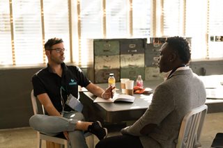 two men sitting at a table having a serious chat
