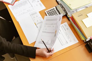 person doing paperwork with lots of information