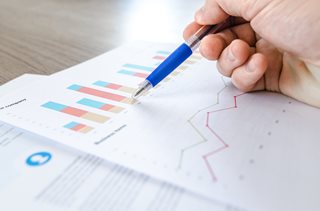hand holding a pen and looking at data