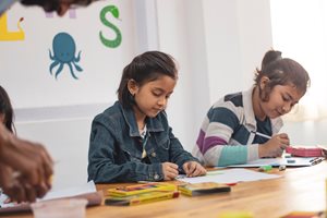 children coloring in a classroom