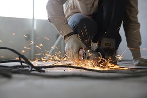 man with a saw cutting into the floor