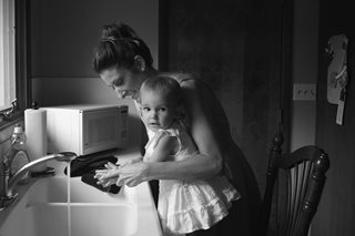 Mother and toddler washing hands at a sink