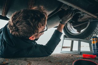 man under a car fixing it