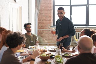 group of young people eating dinner and talking