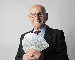 old man in suit holding money