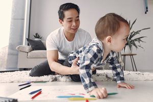 man drawing a picture with his baby