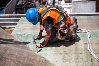 construction workers hammering on a roof