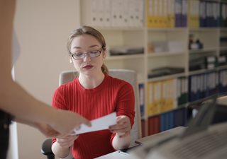 woman looking at a paper in an office