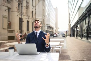 man frustrated in front of laptop