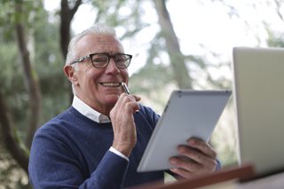 old man working on an ipad