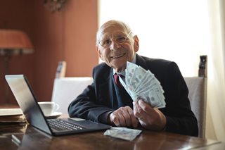old man holding a bunch of cash
