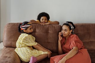 woman sitting on a couch with her children