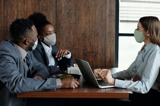 three people meeting while wearing masks