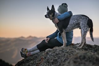 woman with her dog on top of a mountain